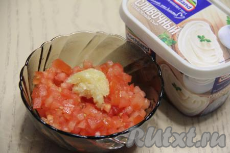 В третью глубокую тарелку выложить мелко нарезанный помидор, добавить пропущенный через пресс чеснок, перемешать.