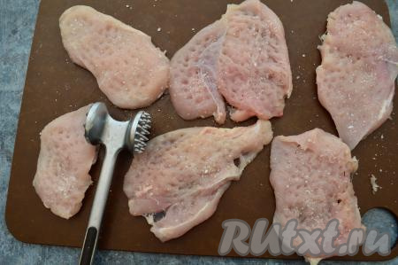 Каждый кусочек мяса отбить кулинарным молоточком до толщины примерно 8-10 миллиметров. Посолить отбитое куриное филе по вкусу с одной стороны.