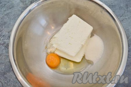 В глубокую миску всыпать сахар, добавить творог и сырое яйцо.