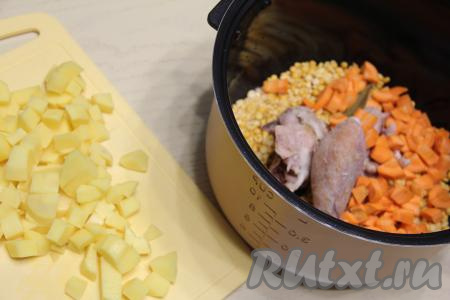 Картошку нарезать на кубики. Нарезанные морковку и картошку тоже добавить в чашу мультиварки.