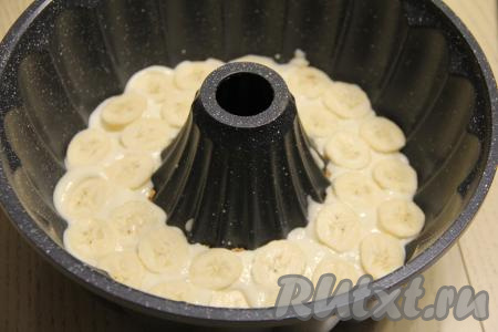 Бананы очистить, нарезать на тонкие кружочки. Выложить половину нарезанных бананов на крем из сгущёнки.