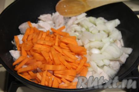 Обжарить мясо курицы, периодически перемешивая, в течение 5 минут на среднем огне. Лук нарезать мелко, морковь - на брусочки. Добавить лук и морковку в сковороду к мясу, перемешать.