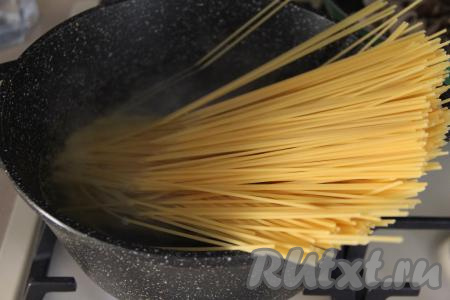 Пока шампиньоны обжариваются в сковороде, вскипятить в кастрюле воду, подсолить и выложить спагетти, дать воде снова закипеть, перемешать. Варить спагетти до готовности (обычно на варку требуется минут 8-9, точное время варки смотрите на упаковке спагетти, которые вы готовите).