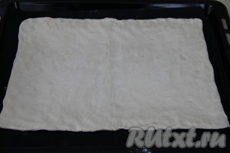 Раскатать тесто немного скалкой и переложить на противень, застеленный ковриком (или пергаментом) для выпечки.