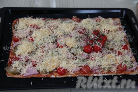 Пиццу с солёными огурцами, колбасой и помидорами сверху посыпать сыром, натёртым на крупной тёрке.