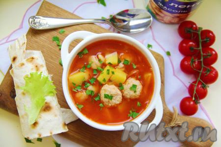 Вкусный, насыщенный томатный суп с фрикадельками и белой консервированной фасолью разлить по тарелкам и в горячем виде подать к столу.