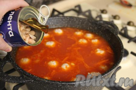 Открыть банку с белой консервированной фасолью, слить излишки жидкости и добавить фасоль в закипевший суп. Посолить по вкусу, довести томатный суп с фрикадельками и фасолью до кипения, затем убавить огонь.