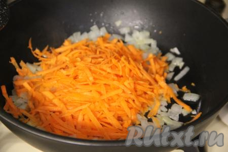К луку, обжаренному до прозрачности, выложить морковь, натёртую на крупной тёрке, сразу перемешать овощи.