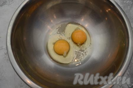В миску вбить сырые яйца и всыпать 2 щепотки соли.