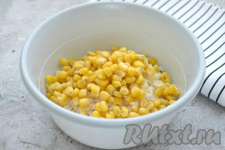 В салатник с рисом добавляем кукурузу без жидкости.