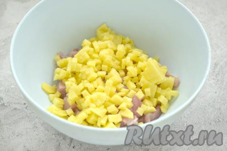 Картошку чистим, тоже нарезаем на очень маленькие кубики, перекладываем в миску с мясом курицы.