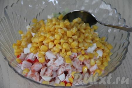 Добавить в салатник кукурузу без жидкости, нарезанные креветки и яйца.