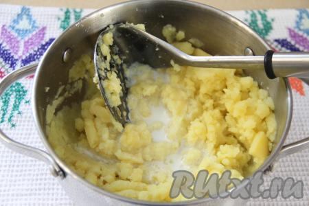 Когда картофель сварится, слить из кастрюли всю жидкость. В кастрюлю с варёным картофелем влить тёплое молоко. Растолочь картошку в пюре.