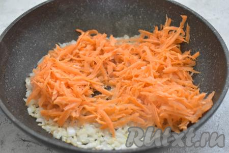 Когда лук станет прозрачным, добавляем к нему натёртую на крупной тёрке морковь, перемешиваем овощи и обжариваем их 4-5 минут (до мягкости моркови), периодически помешивая.