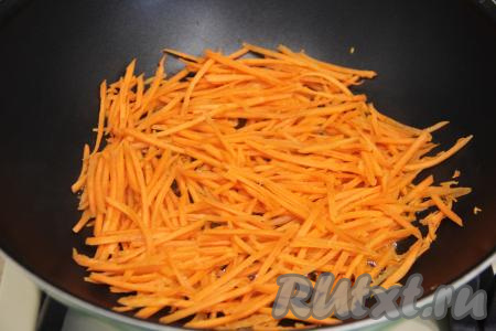 Морковь натереть на тёрке для корейской моркови (если нет такой тёрки, тогда нарежьте морковь на тонкие брусочки или натрите на крупной тёрке). Разогреть растительное масло в сковороде, выложить морковку и обжаривать её минут 5 на среднем огне, иногда помешивая.