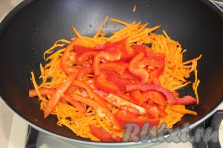 К обжаренной моркови выложить нарезанный болгарский перец, перемешать. Обжаривать овощи минут 5, периодически помешивая. 