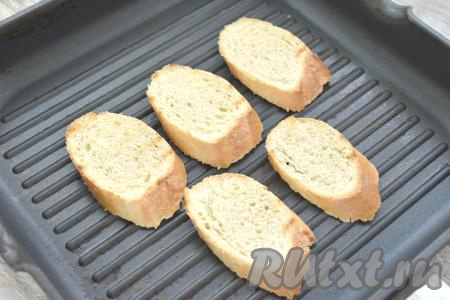 Хорошо разогреваем сухую сковороду (у меня - сковорода гриль), выкладываем кусочки багета (или батона), подсушиваем на среднем огне белый хлеб с двух сторон. Можно подсушить кусочки хлеба и в тостере или в прогретой до 180 градусов духовке в течение 5-6 минут.