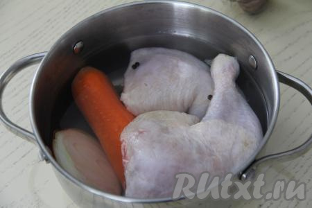 Выложить куриные окорочка в кастрюлю, добавить лук, морковь, горошины перца, лавровый лист, влить 600 миллилитров воды.