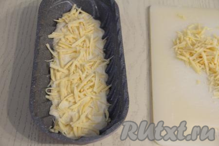 Сыр натереть на крупной тёрке. Присыпать тесто половиной натёртого сыра.