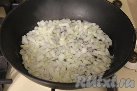 В сковороду влить растительное масло, немного разогреть его, затем выложить мелко нарезанный лук. Обжаривать лук до прозрачности (ориентировочно минуты 3-4) на среднем огне, периодически перемешивая.