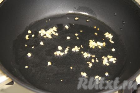 В сковороду влить растительное масло, разогреть, выложить очищенный и мелко нарезанный чеснок, обжаривать его 1 минуту на среднем огне, иногда перемешивая.