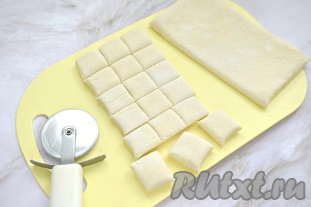 Размороженное слоёное тесто выкладываем на стол. Раскатывать тесто не нужно. Нарезаем пласт теста на квадратики со сторонами по 2,5-3 сантиметра. Из 125 грамм теста получается 18 квадратиков.