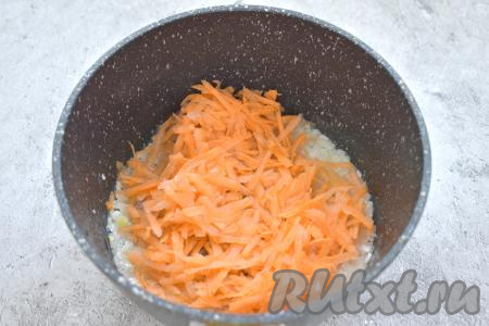 К обжаренному луку выкладываем натёртую на крупной тёрке морковь, перемешиваем и обжариваем 4-5 минут (морковка должна стать мягкой).