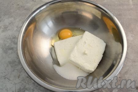 В глубокую миску всыпать сахар, выложить творог и сырое яйцо.