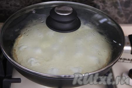 Накрыть сковороду крышкой и готовить омлет с творожным сыром на медленном огне минут 10.