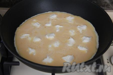 Выложить творожный сыр небольшими кусочками поверх яично-молочной смеси.