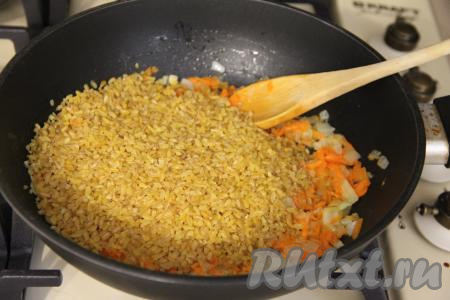 В сковороду с обжаренными овощами добавить булгур, перемешать, всыпать соль и специи по вкусу, перемешать.