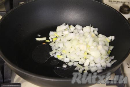 Почистить лук и морковь. Прогреть растительное масло в сковороде, выложить мелко нарезанный лук, обжарить его до прозрачности (в течение 3-4 минут), иногда помешивая. 