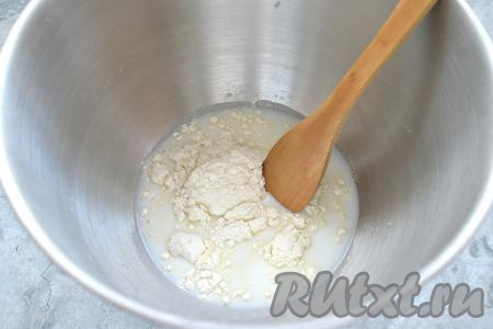Дрожжи и сахар заливаем тёплым молоком (примерная температура молока 38-40 градусов) и добавляем 2 столовых ложки муки, хорошо перемешиваем лопаткой (или столовой ложкой). В получившейся дрожжевой смеси не должно быть комочков. Миску с дрожжевой смесью накрываем крышкой и оставляем в тёплом месте на 20 минут.