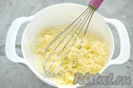 В получившуюся яично-сметанную смесь выкладываем сыр, натёртый на мелкой тёрке.