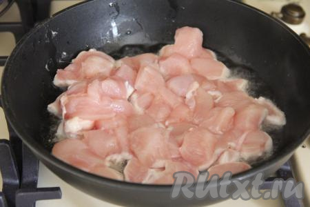 Нарезать мясо курицы на кубики размером 1,5 сантиметра на 1,5 сантиметра. В сковороду влить растительное масло, разогреть его, выложить кусочки курицы. 