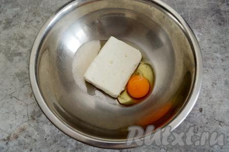 В глубокую миску выложить творог, вбить сырое яйцо и всыпать сахар.