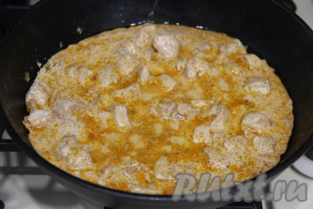 Перемешать, дать сметанному соусу закипеть, уменьшить огонь до минимума, тушить мясо курицы под крышкой 5 минут.