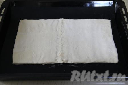 Перевернуть тесто и слегка раскатать его скалкой до толщины, примерно, 4 миллиметра. Переложить заготовку на противень, застеленный ковриком (или пергаментом) для выпечки.