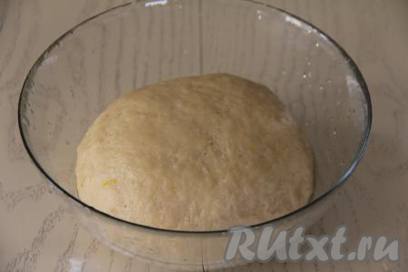 Выложить тесто в миску, смазанную растительным маслом, накрыть полотенцем и поставить в тёплое место часа на 1,5  (до увеличения теста в объёме раза в 2). Пока тесто подходит, можно заняться изюмом. Изюм следует залить кипятком и оставить на 5-10 минут. Затем воду слить, а изюм обсушить на бумажном полотенце.