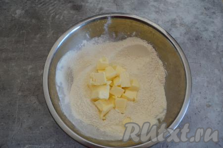 Прежде всего замесим песочное тесто. Для этого в глубокой миске нужно соединить муку, разрыхлитель и сахар, перемешать до однородности. Затем добавить сливочное масло из холодильника, нарезанное на небольшие кусочки.