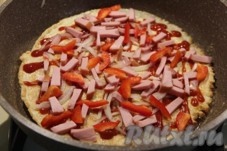 Выложить на овсяноблин начинку для пиццы: нарезанную колбасу, лук, перец и помидоры.