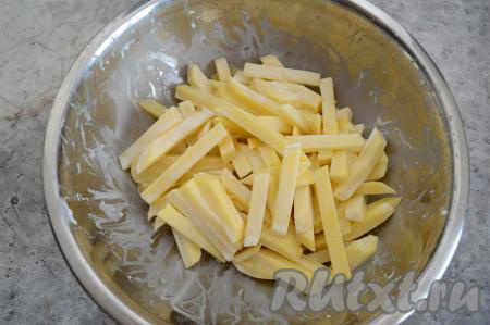 Перемешать картошку со сметаной, покрывая брусочки картофеля сметаной со всех сторон.