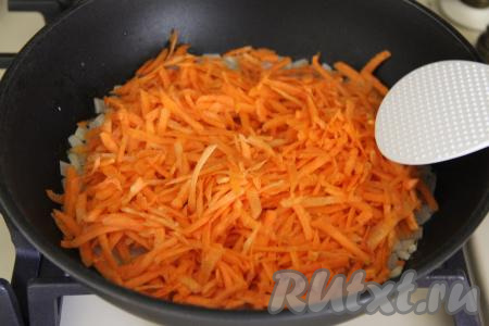 Затем выложить морковку, натёртую на крупной тёрке, сразу перемешать овощи.
