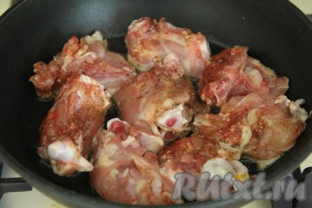 Сковороду поставить на сильный огонь, влить растительное масло и разогреть. Выложить части курицы в сковороду.