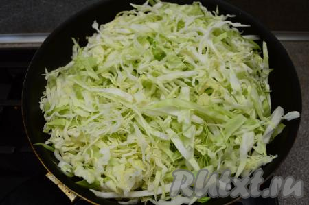 В сковороду влить растительное масло, разогреть, затем выложить нарезанную молодую капусту.
