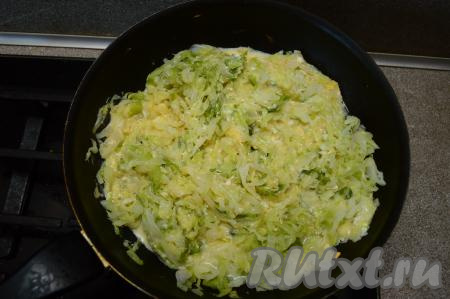 Сразу столовой ложкой (или лопаткой) перемешать яйца с капустой, посолить. Накрыть сковороду крышкой и готовить ещё 5 минут.