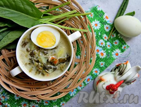 Вкусный, насыщенный суп, приготовленный с щавелем и плавленным сыром, разлить по тарелкам и с долькой варёного яйца подать к столу. 