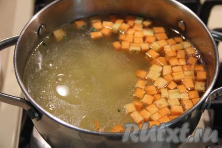 В закипевший куриный бульон выложить морковку с картофелем, дать закипеть и варить на небольшом огне 15 минут (овощи должны стать достаточно мягкими).