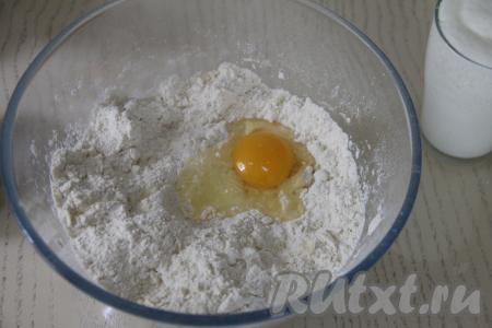 В миску с масляно-мучной крошкой вбить сырое яйцо.