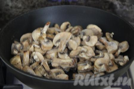 Если вы будете готовить это блюдо со свежими шампиньонами, тогда их нужно промыть водой, нарезать на пластины. Если же вы будете использовать замороженные нарезанные шампиньоны, тогда размораживать их не нужно. В отдельной сковороде разогреть масло, после этого выложить нарезанные свежие (или замороженные) шампиньоны, обжарить грибы, иногда помешивая, на среднем огне в течение 10 минут. Немного подсолить шампиньоны в процессе обжаривания.